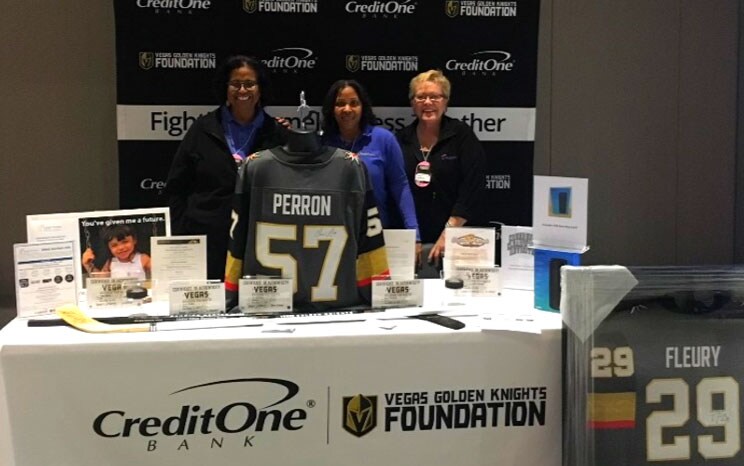 Individuals standing at a Vegas Golden Knights booth, showcasing a jersey