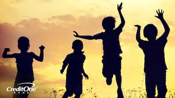 Silhouette of four young kids jumping with the sunset hitting them from behind