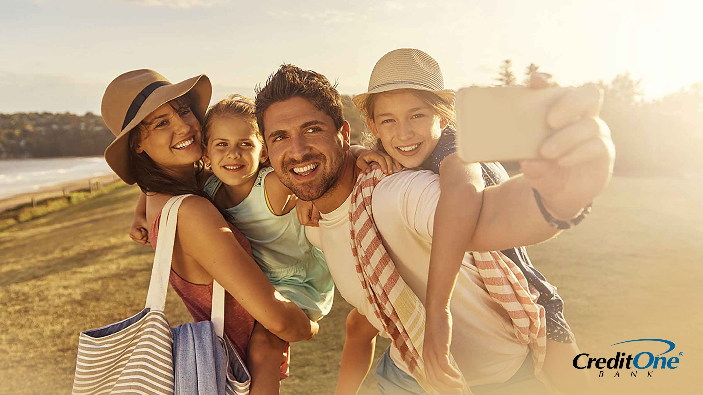 A father and mother with their two daughters taking a photo on vacation