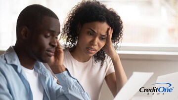 A man and a woman sitting and reviewing financial statements while applying for a credit card with bad credit