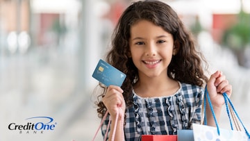 A young girl shops in the mall with a credit card