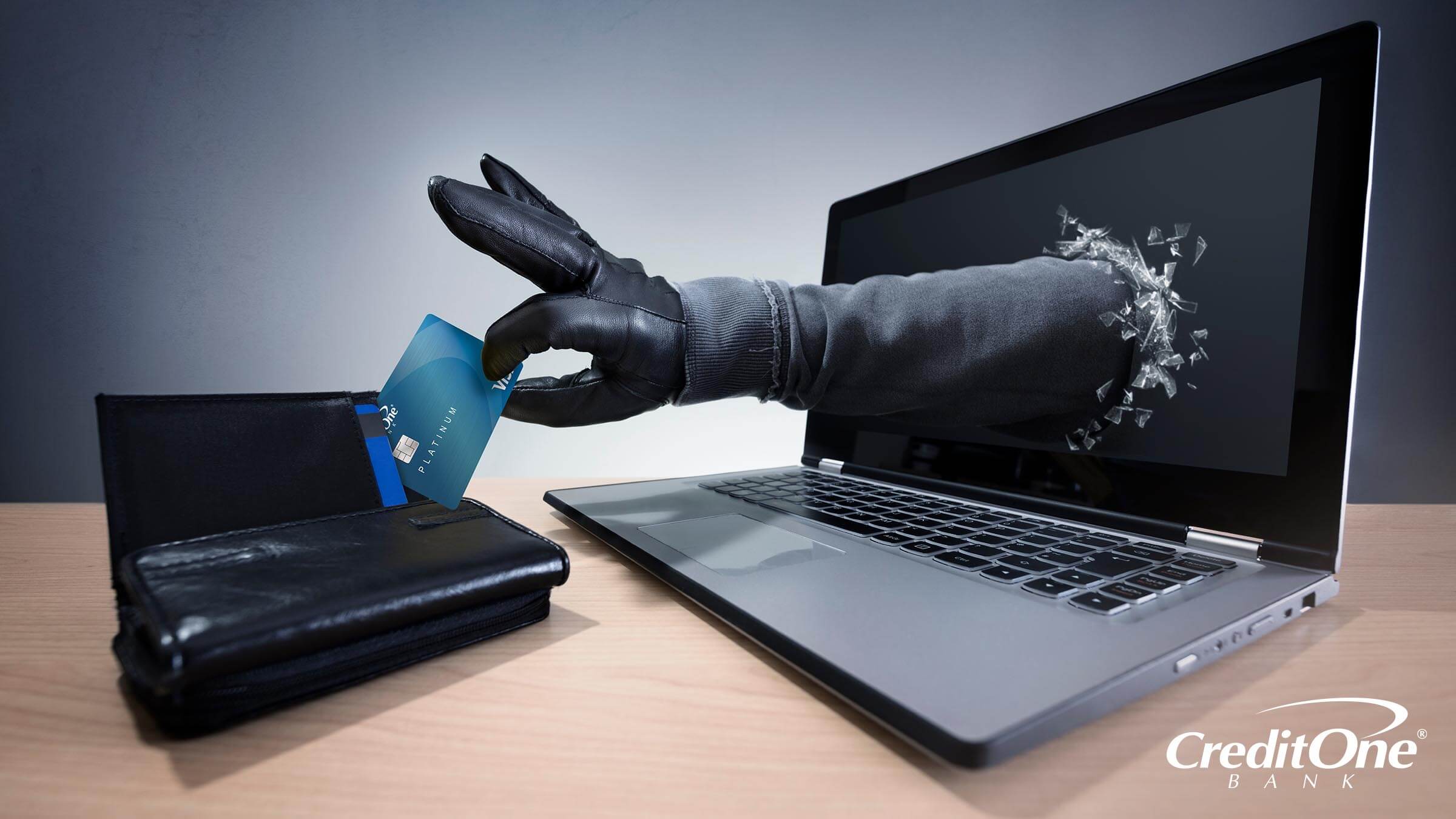 A credit card scammer reaching through a computer to steal from your wallet