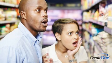 A couple gasps in horror at the food prices while trying to fight inflation at the grocery store