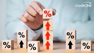 A businessman stacks blocks with percentage signs and upward arrows to signify rising CD rates