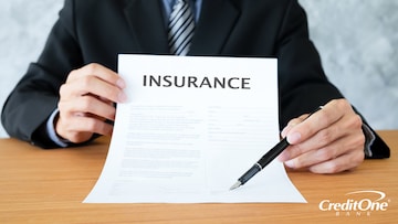 An insurance agent holds a policy ready to sign, outlining the agreement on insurance premiums