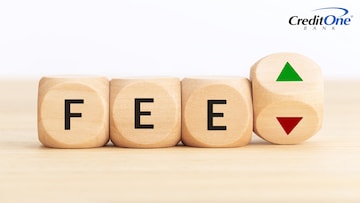 The word “fee” is spelled out on wooden cubes next to a cube with up and down arrows on it, signifying whether credit card annual fees are worth it or not.