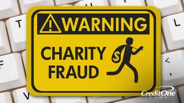 A warning sign stating, “charity fraud” rests on top of a keyboard.