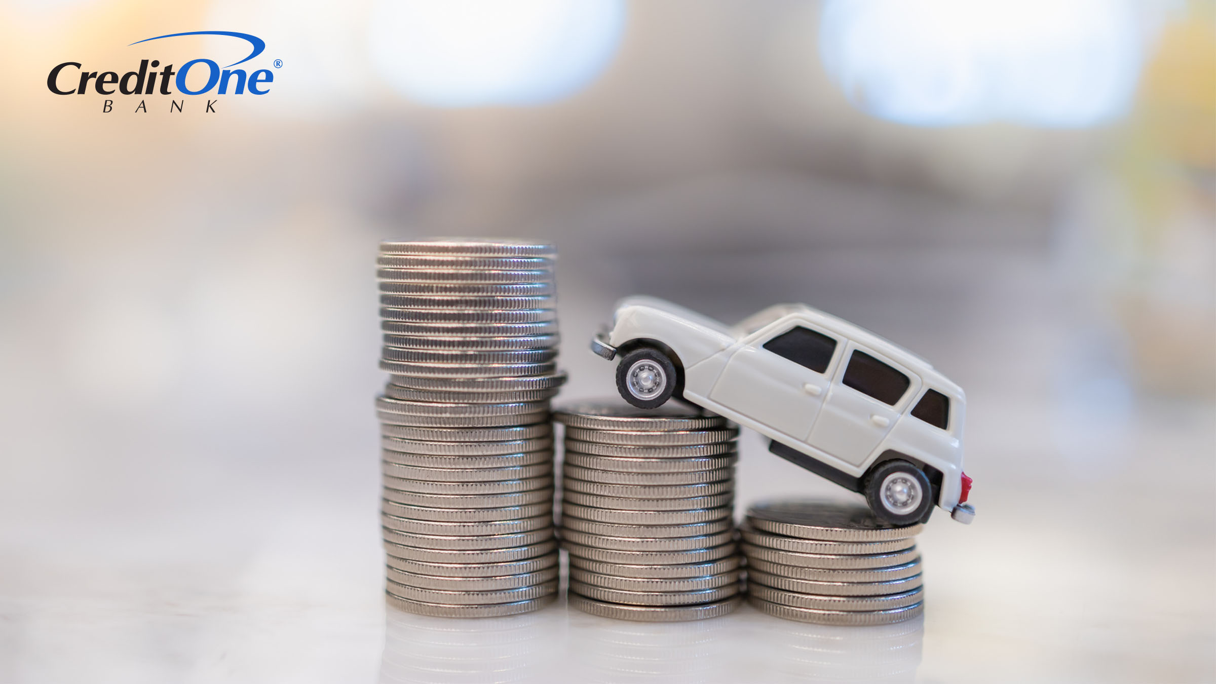 A toy car is climbing a stack of coins, representing auto insurance rates going up.