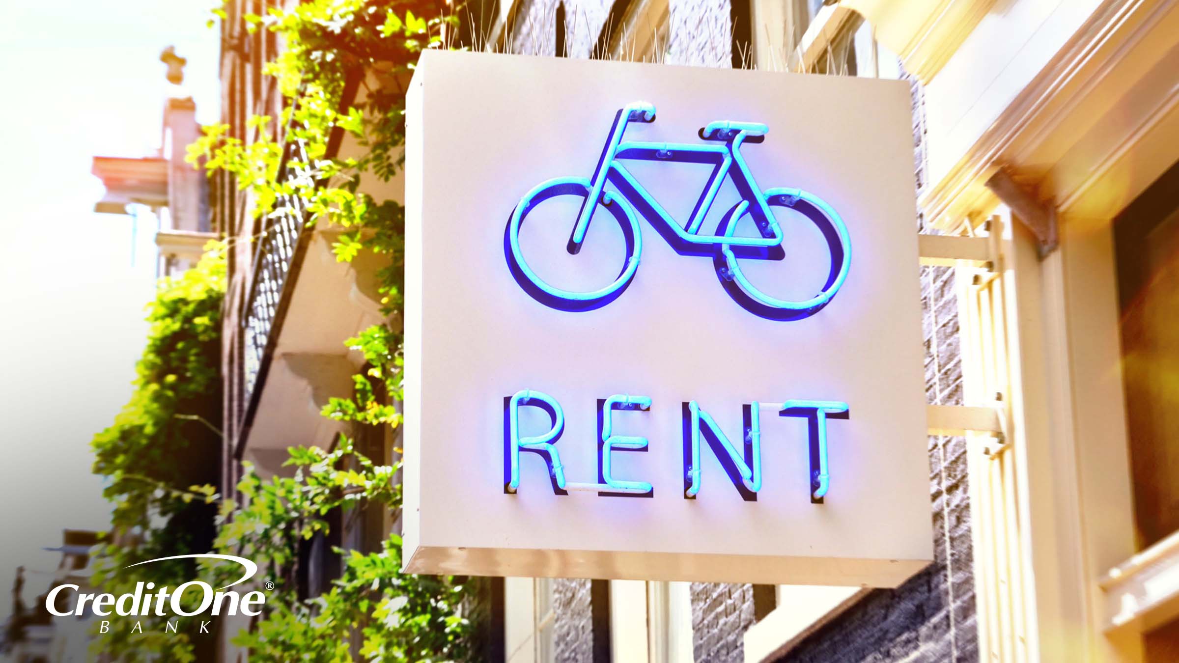A store sign shows a neon bicycle with the word “Rent,” indicating that rental is the new purchase.