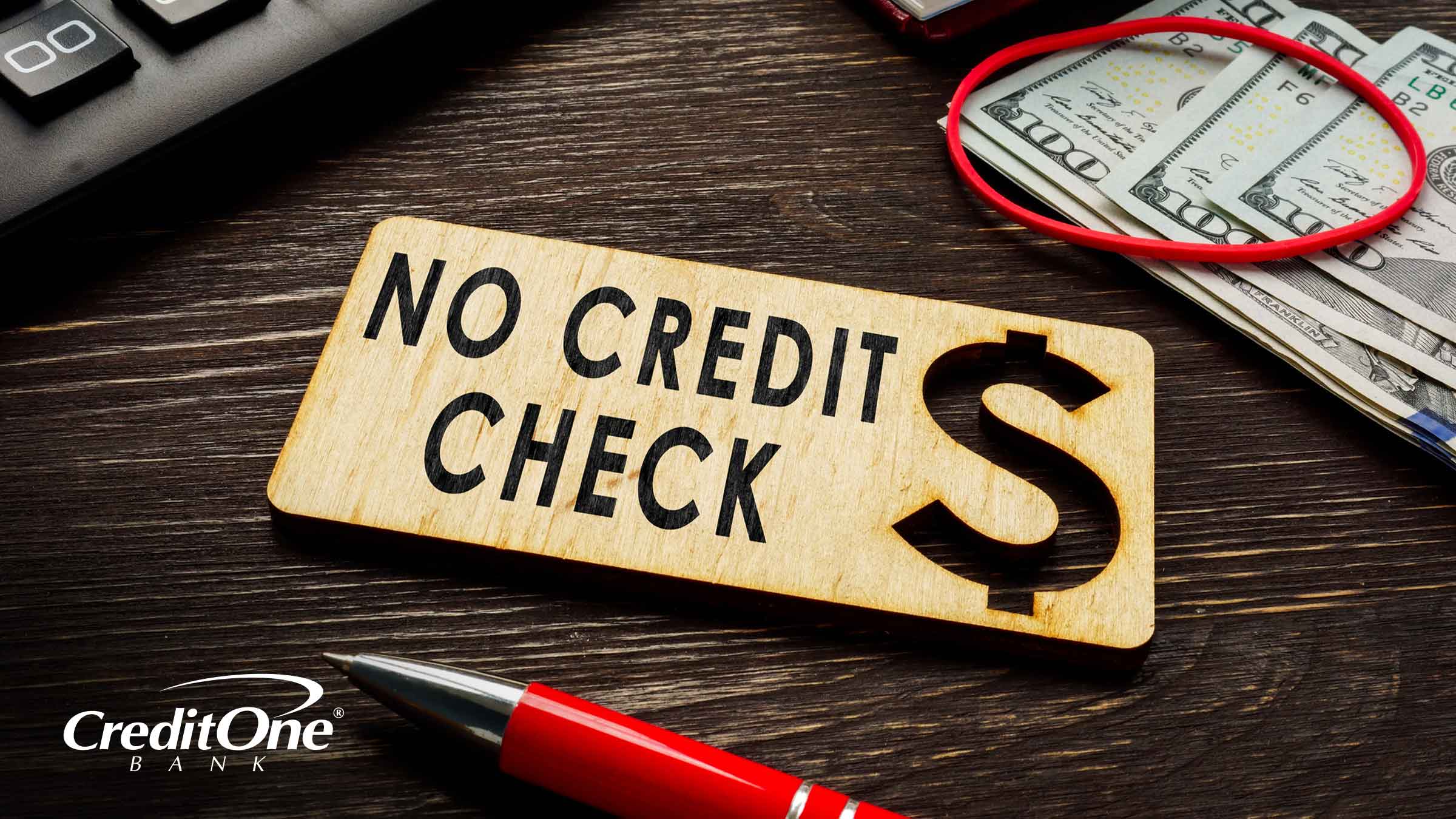 A sign beside a calculator and stack of money reads “No Credit Check” which indicates the process of getting credit without a hard pull. 