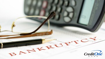 A page titled Bankruptcy sits on a desk beside a calculator and pen, ready to create a plan to rebuild credit.