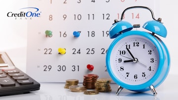 An alarm clock, calculator and pile of coins are in front of a paper calendar, which has color-coded push pins placed at various dates. These objects represent the various aspects of recurring billing.