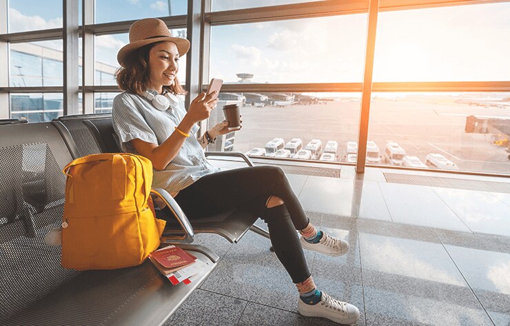 A Woman at Airport Looking at Her Phone