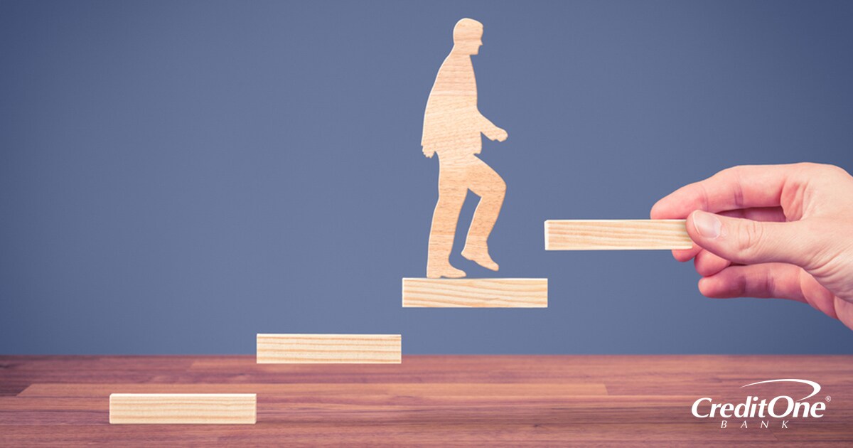 Demonstrating improved credit success by wooden block shaped like a man walking up a set of stairs Demonstrating improved credit success by wooden block shaped like a man walking up a set of stairs