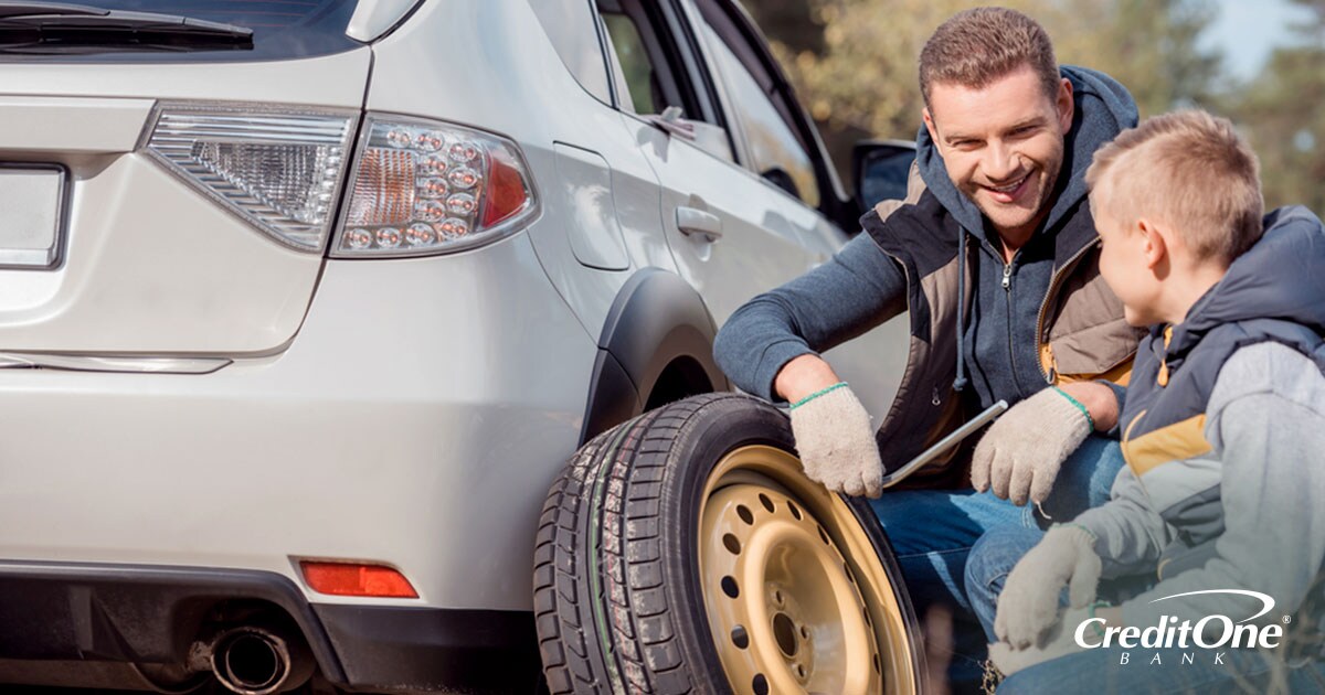 Father and son handling an auto repair emergency by replacing a tire Father and son handling an auto repair emergency by replacing a tire