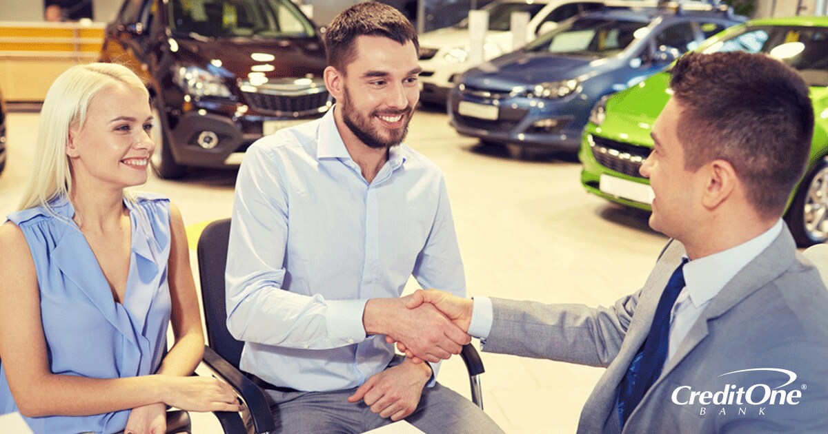 Couple with good credit closing the deal on a brand new car at a car dealership Couple with good credit closing the deal on a brand new car at a car dealership