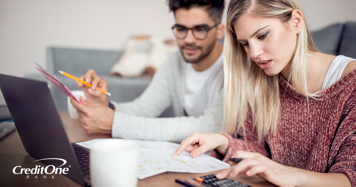 A young couple checking their credit and reviewing their financial statements A young couple checking their credit and reviewing their financial statements