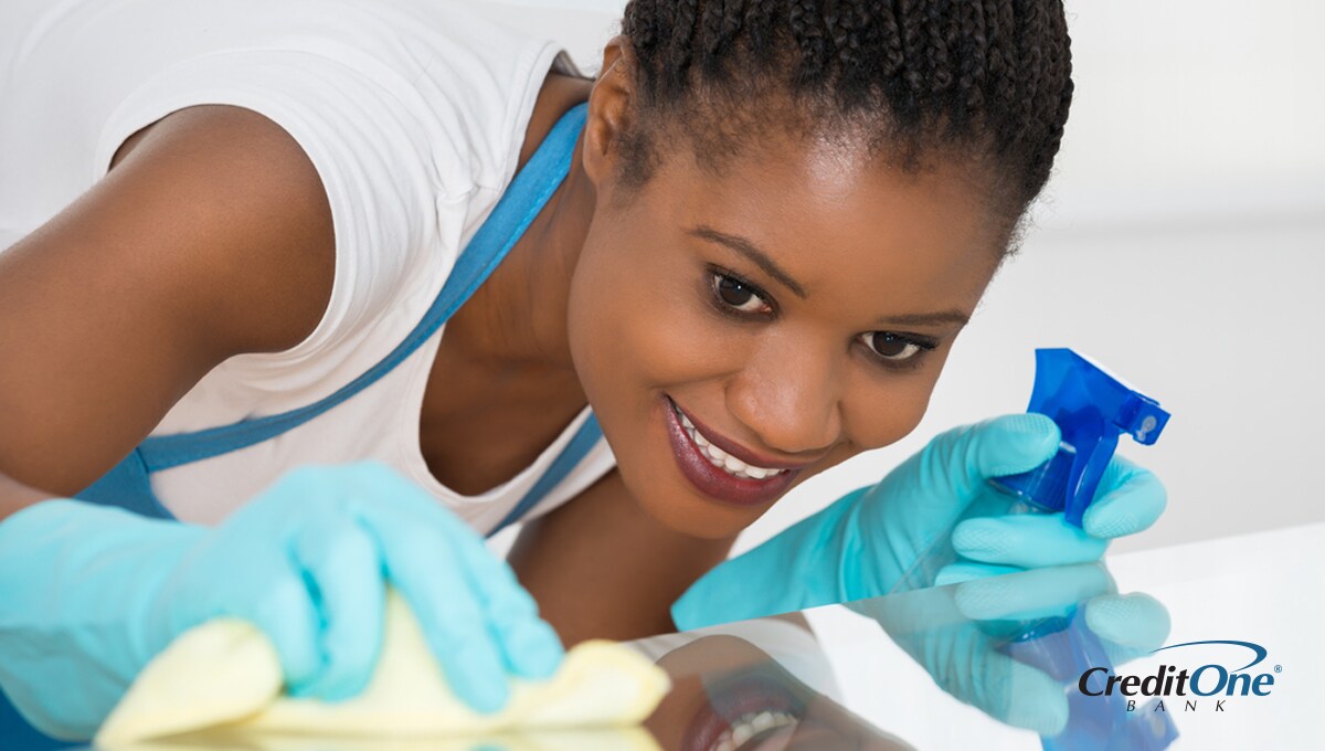 A woman spring cleaning her home with cleaning spray and a cloth A woman spring cleaning her home with cleaning spray and a cloth