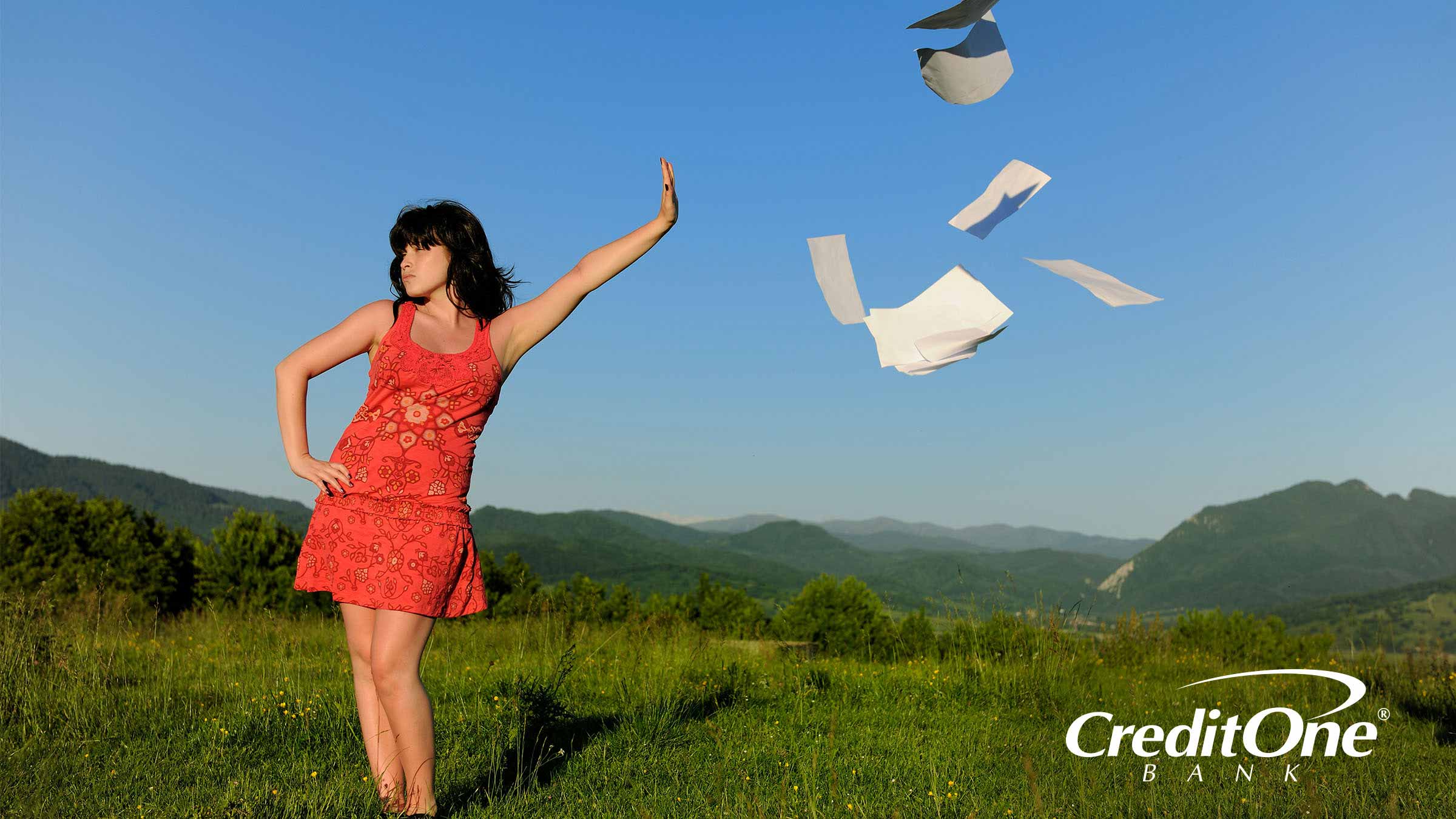 Woman in the sun tossing papers away as she goes paperless Woman in the sun tossing papers away as she goes paperless