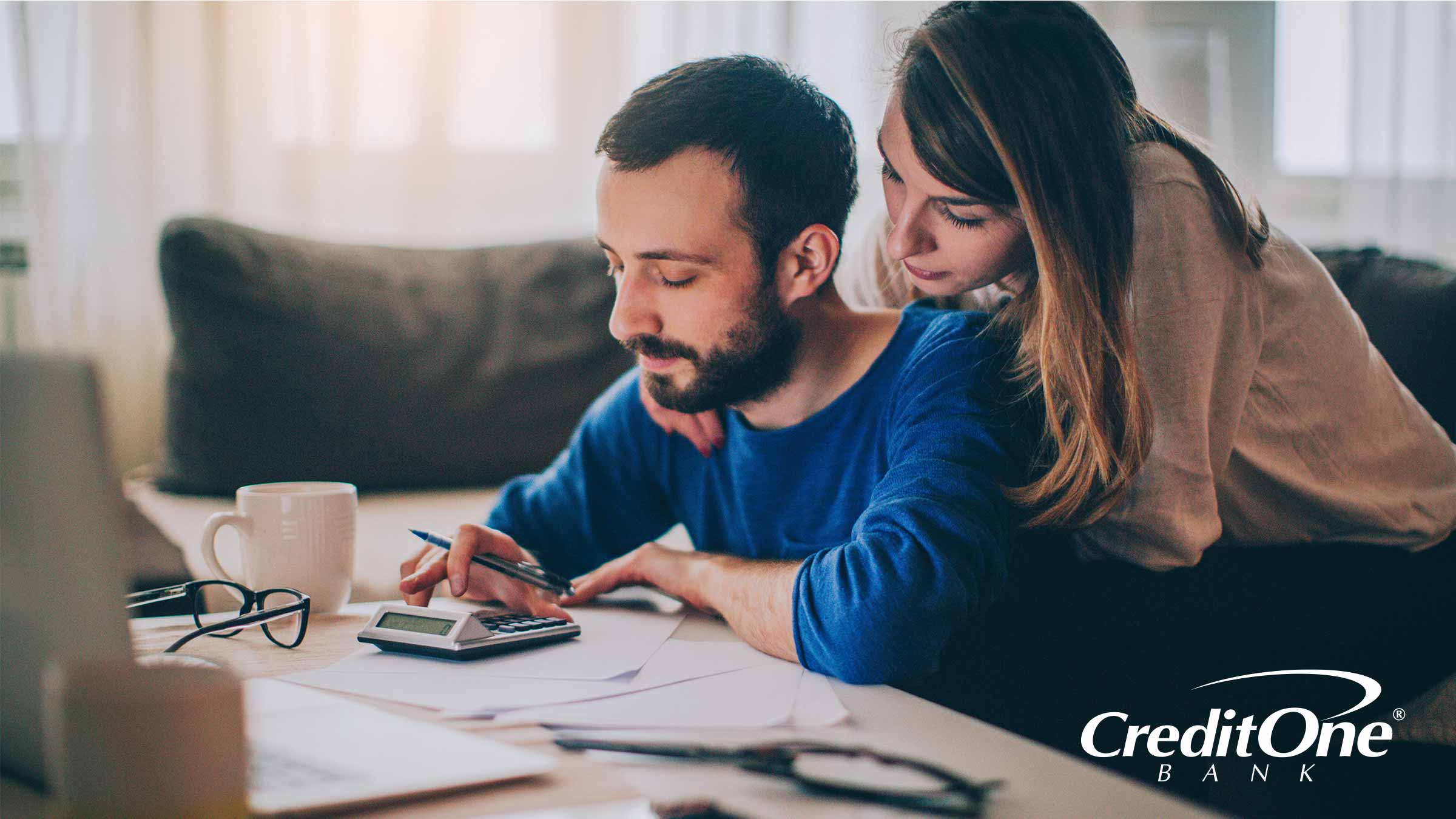 Couple at kitchen table calculating their debt Couple at kitchen table calculating their debt