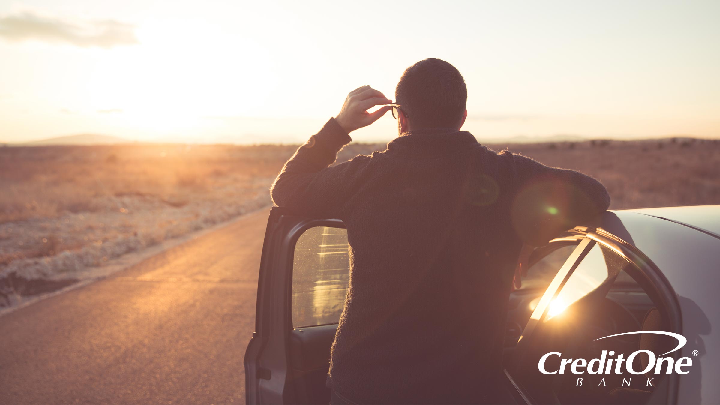 Man standing outside of his car staring to see what is beyond the horizon Man standing outside of his car staring to see what is beyond the horizon