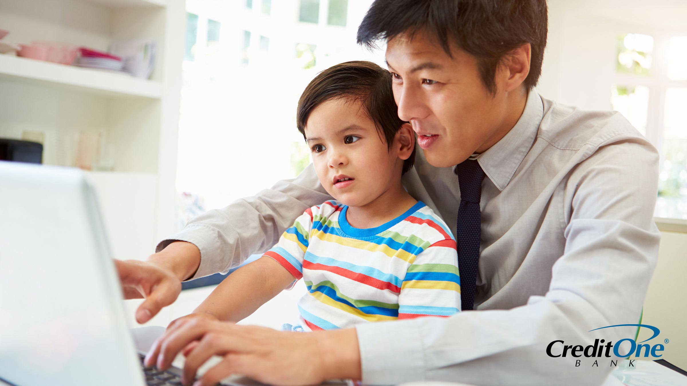 Father showing his infant son a budget on the computer Father showing his infant son a budget on the computer