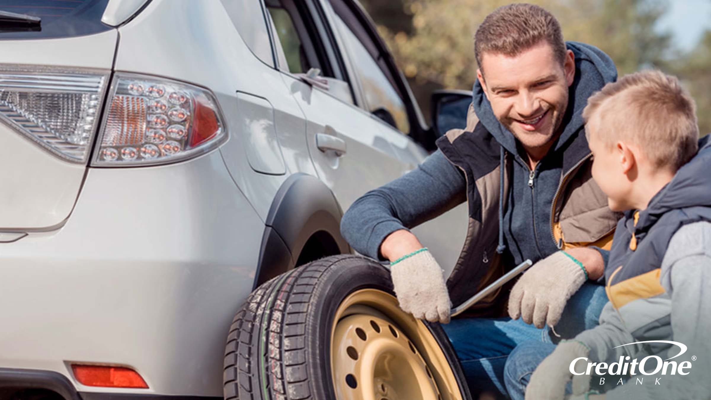 Father and son handling an auto repair emergency by replacing a tire Father and son handling an auto repair emergency by replacing a tire