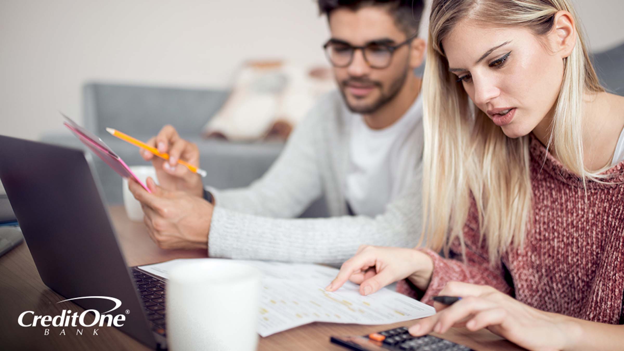 A young couple checking their credit and reviewing their financial statements A young couple checking their credit and reviewing their financial statements