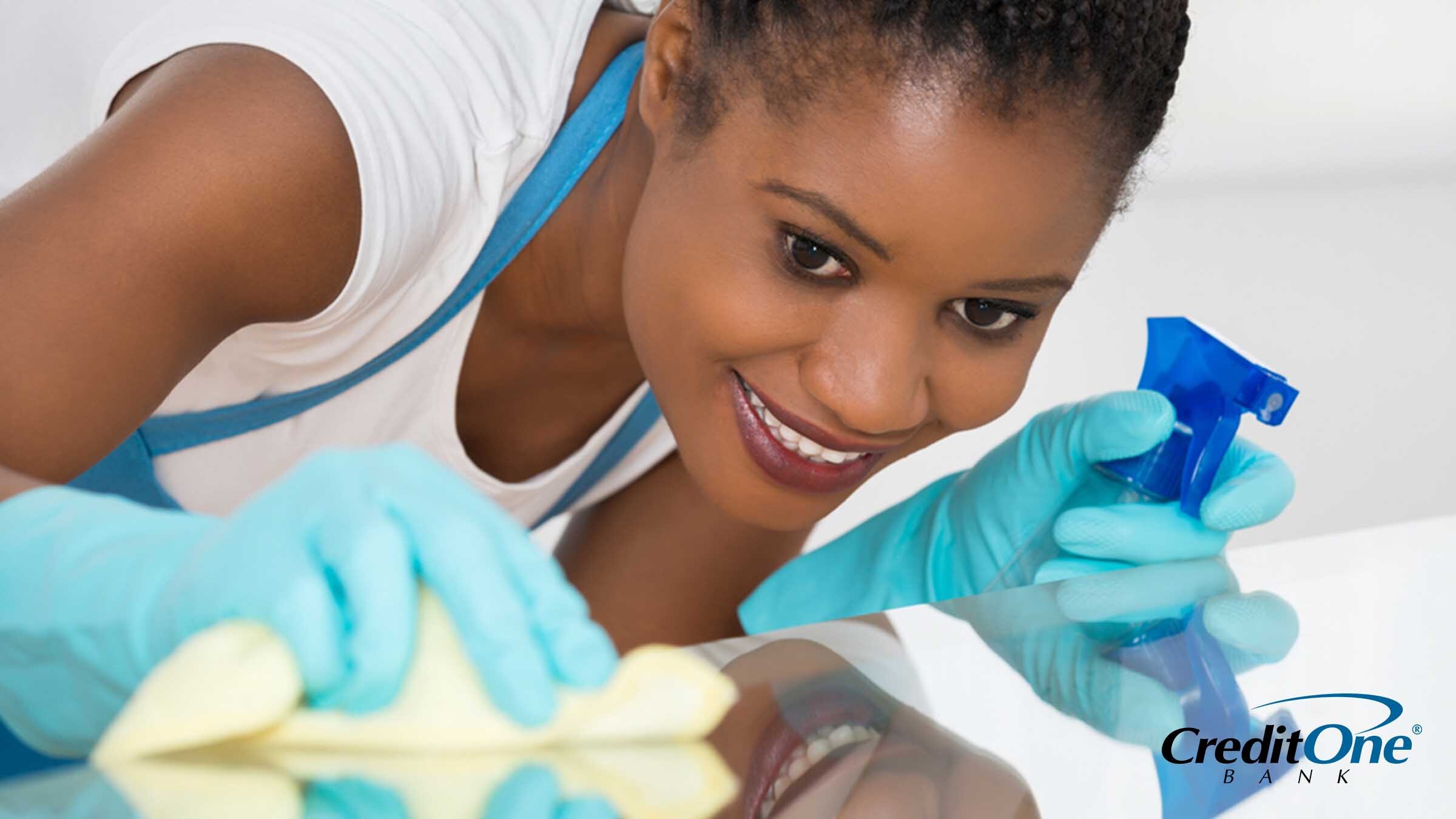 A woman spring cleaning her home with cleaning spray and a cloth A woman spring cleaning her home with cleaning spray and a cloth