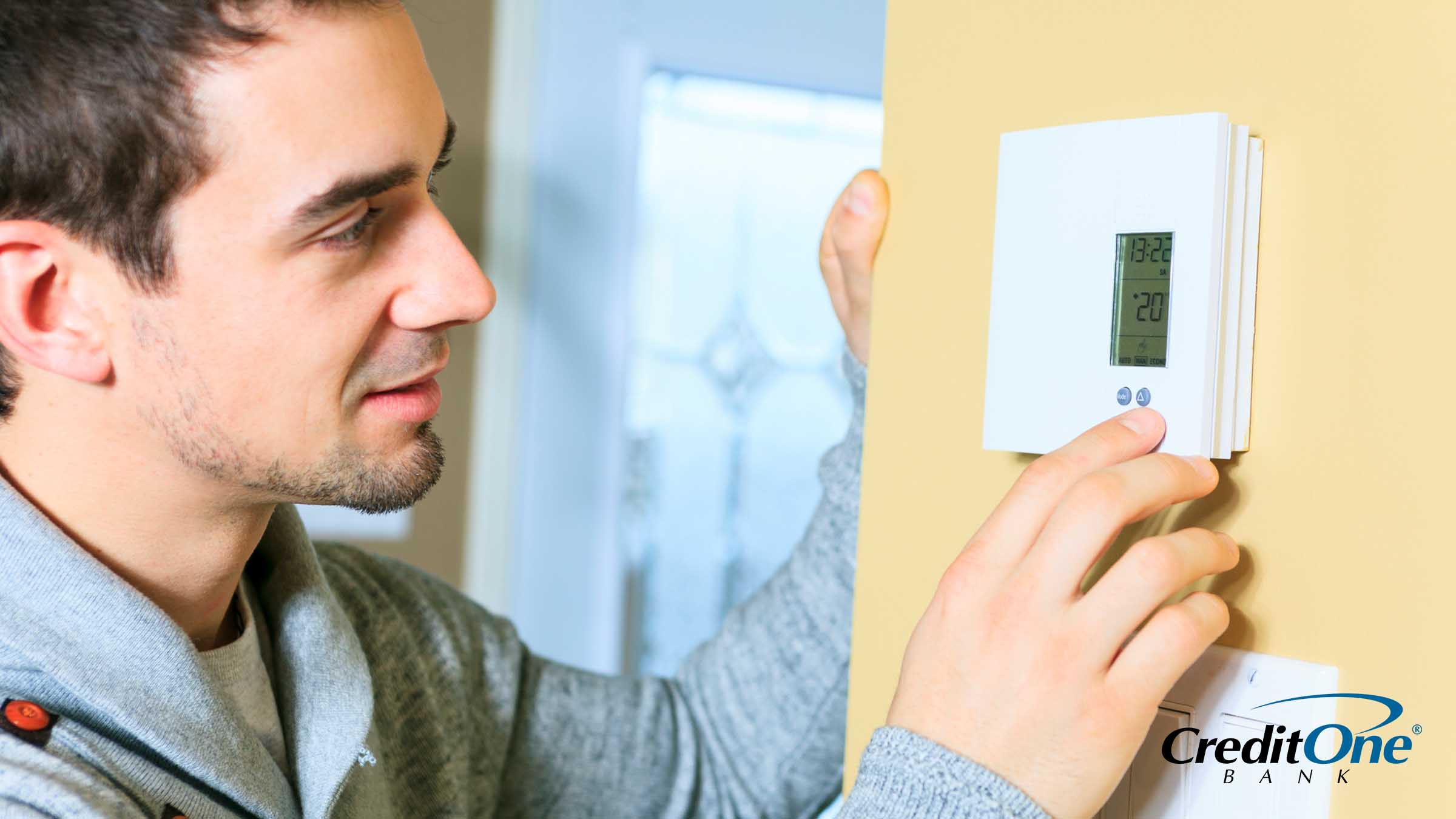 A man checking the thermostat in his home