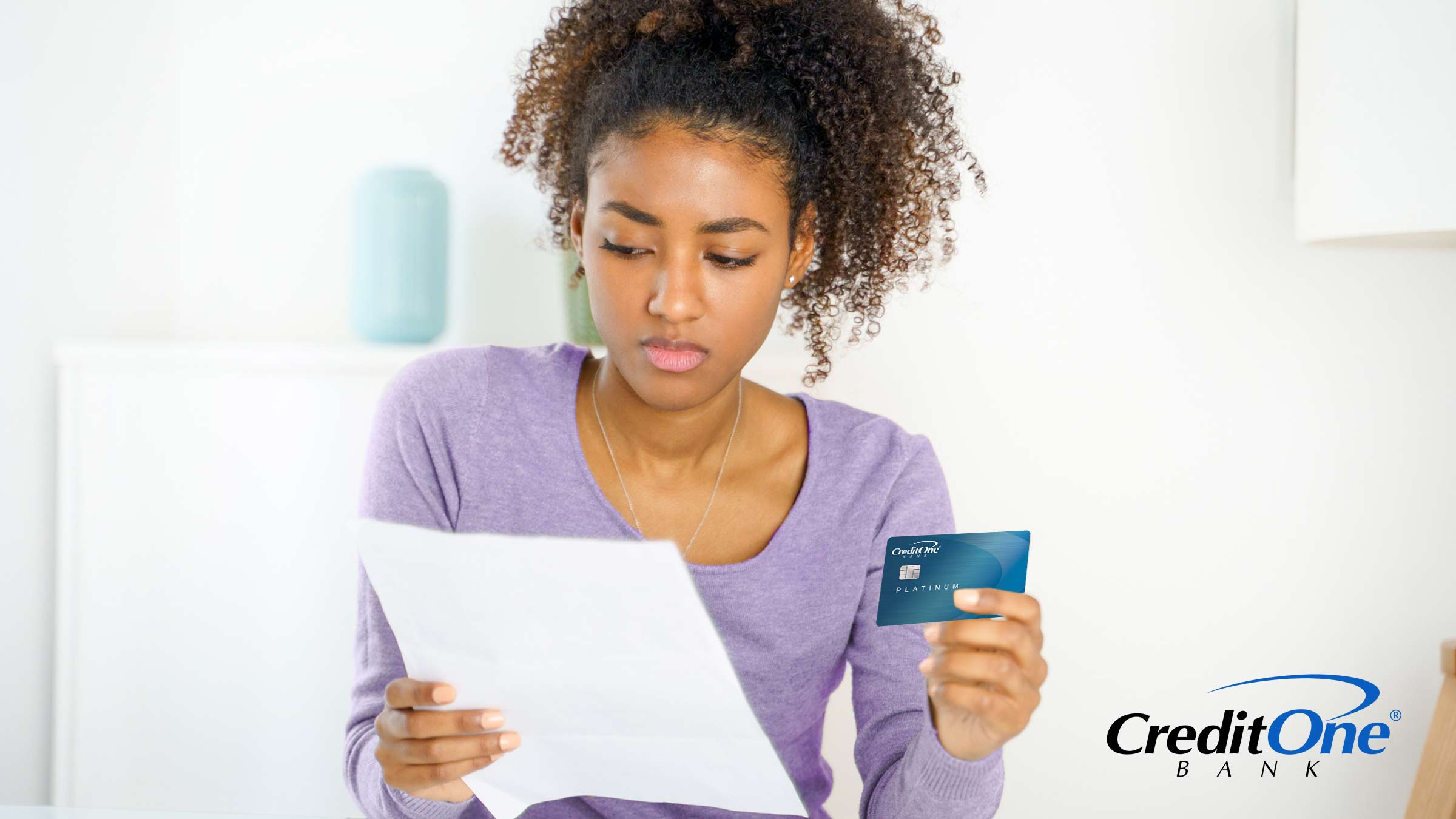 A woman looks confused with something on her credit card bill. A woman looks confused with something on her credit card bill.