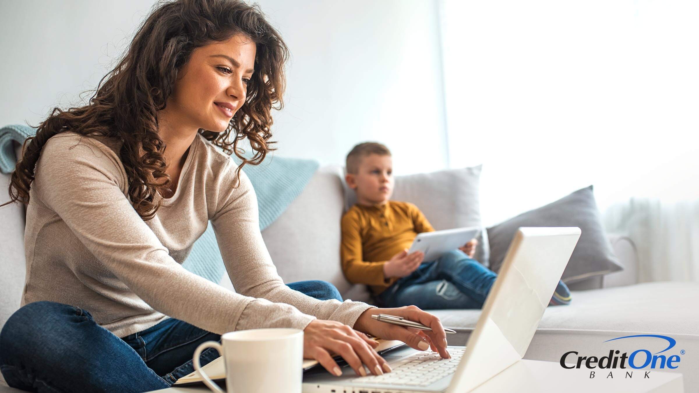 Mother smiling while working on finances with kid playing on tablet. Mother smiling while working on finances with kid playing on tablet.