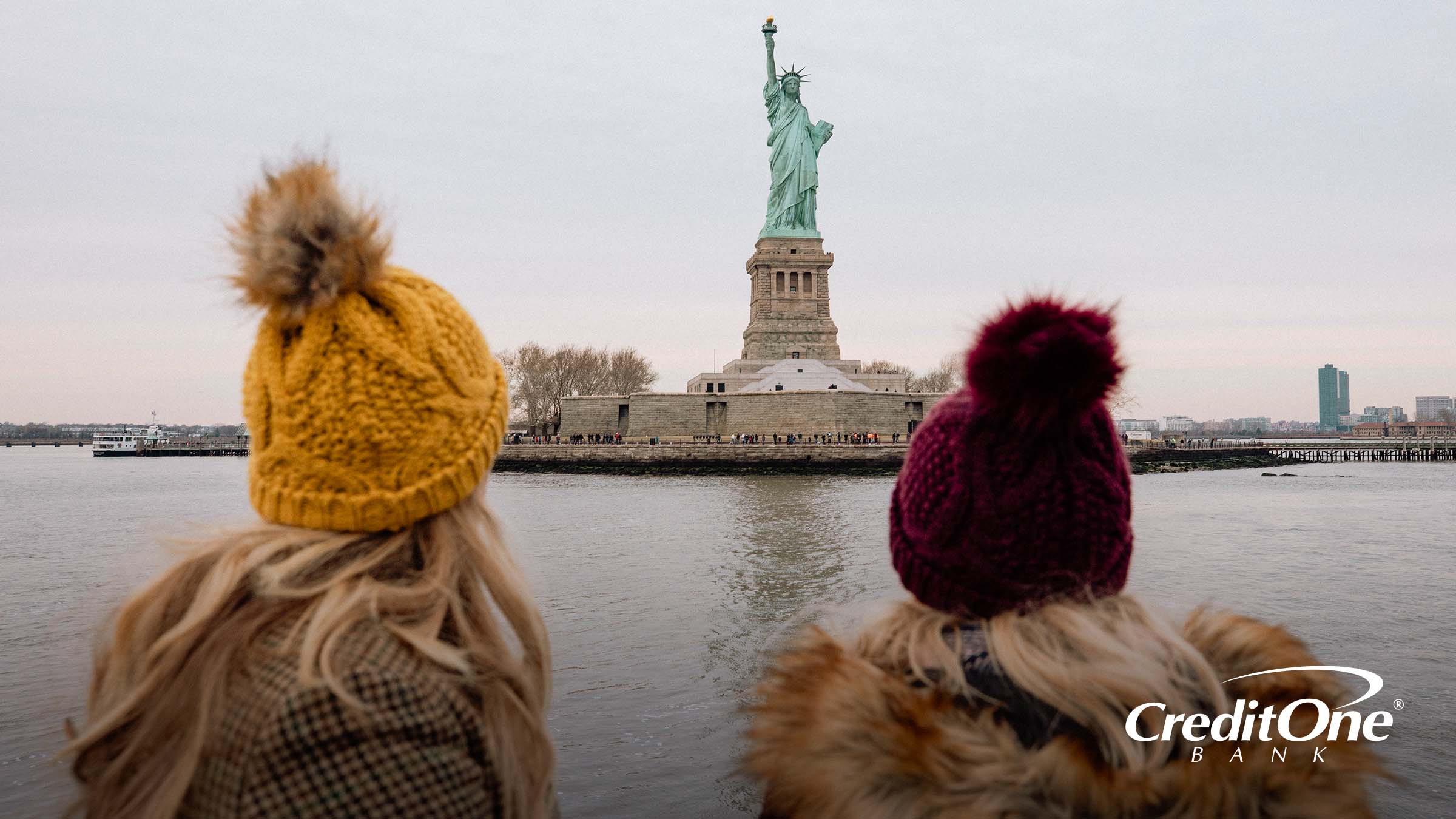 Tourists view the Statue of Liberty from the ferry on a budget travel vacation
