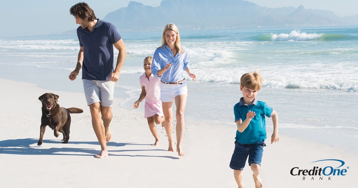 Family of four with a dog running on a beach during a family vacation Family of four with a dog running on a beach during a family vacation