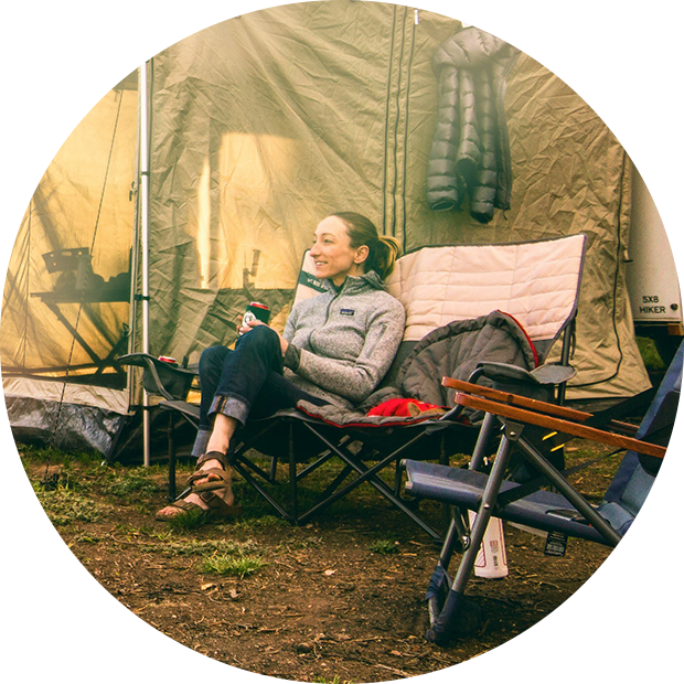 Woman sitting next to a tent