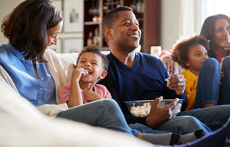 A Family Sitting on the Couch Eating Popcorn