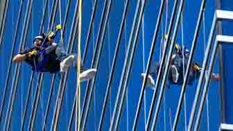 A man rappelling down a building